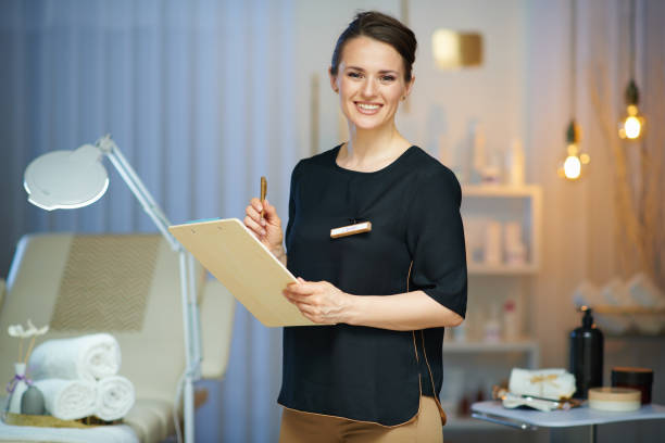 smiling female worker with clipboard in modern beauty studio.